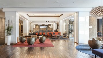 Un hall d’entrée spacieux au design moderne, comprenant un grand espace salon, un meuble à vin et une vue sur la cave à vin.