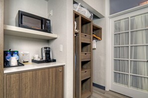 A kitchenette with a microwave, coffee maker, and bottled water. There is a wooden cabinet and a glass door with curtains. - Hilton Garden Inn Livermore (Livermore)