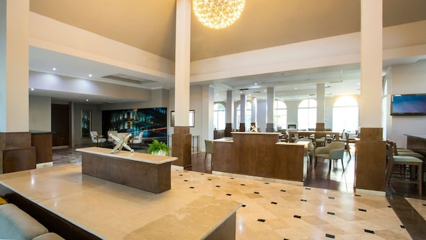 A spacious lobby with a reception desk, seating area, and large windows allowing natural light. - Krystal Urban Ciudad Juárez by US Consulate (Ciudad Juárez)