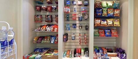 A well-organized pantry with various food items, snacks, and household supplies.