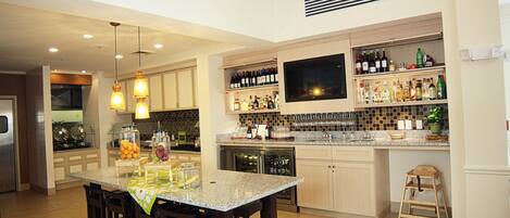 A modern kitchen with a granite countertop, wooden cabinets, and a built-in wine rack.