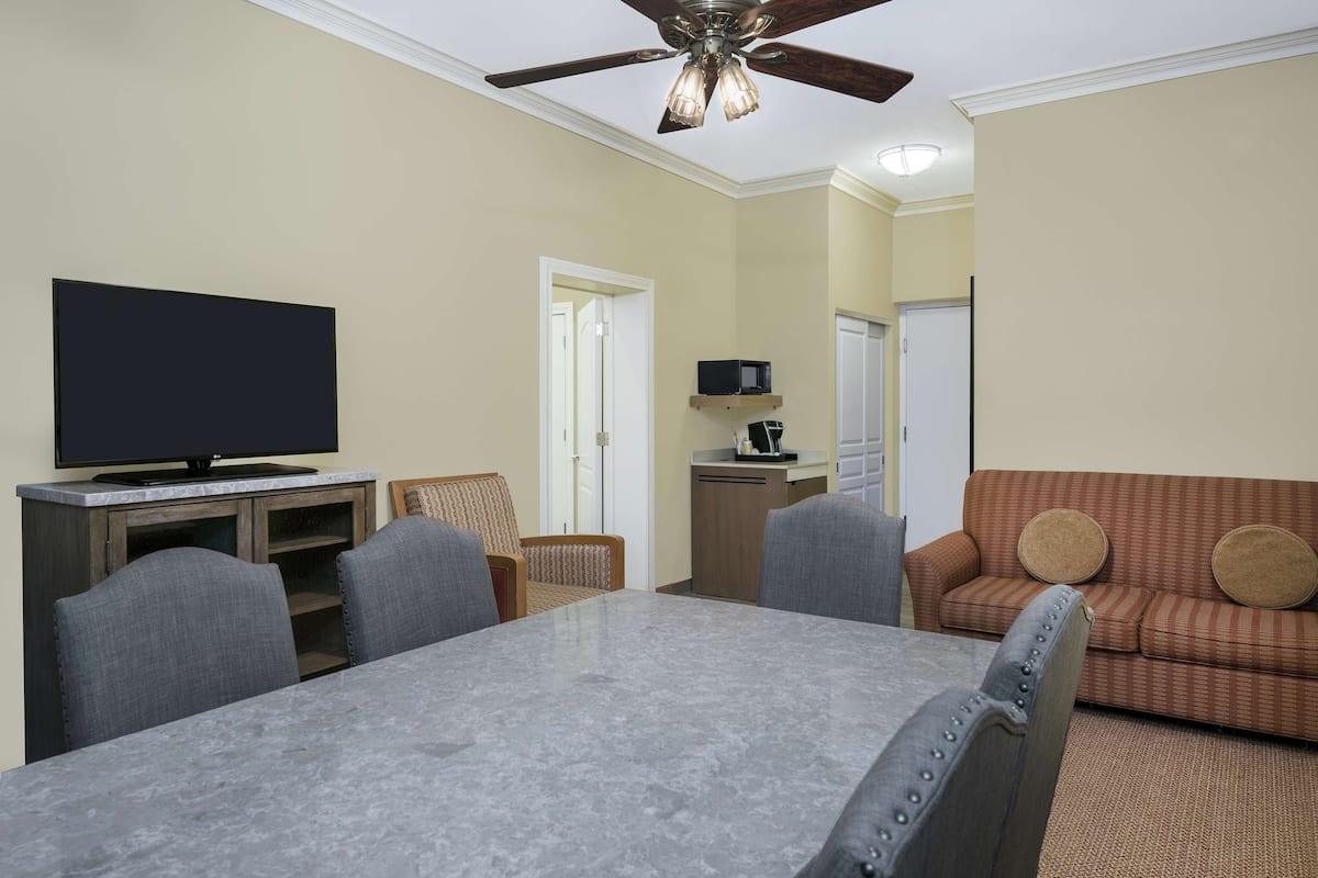 A living room with a TV, a dining table, and a sofa.