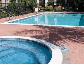 Una piscina al aire libre, sillones reclinables de piscina