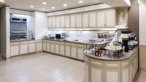 Una cocina amplia con una isla central, equipada con varios electrodomésticos y expositores de alimentos.