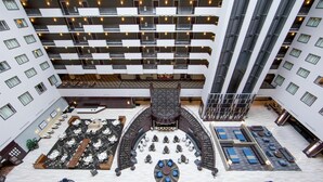 A multi-level hotel lobby with a central atrium, multiple seating areas, and balconies. - Hilton Nashville Downtown (Nashville)