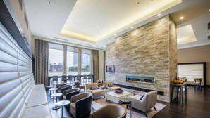 A modern lounge area with sofas, chairs, and a fireplace. - Hilton Nashville Downtown (Nashville)