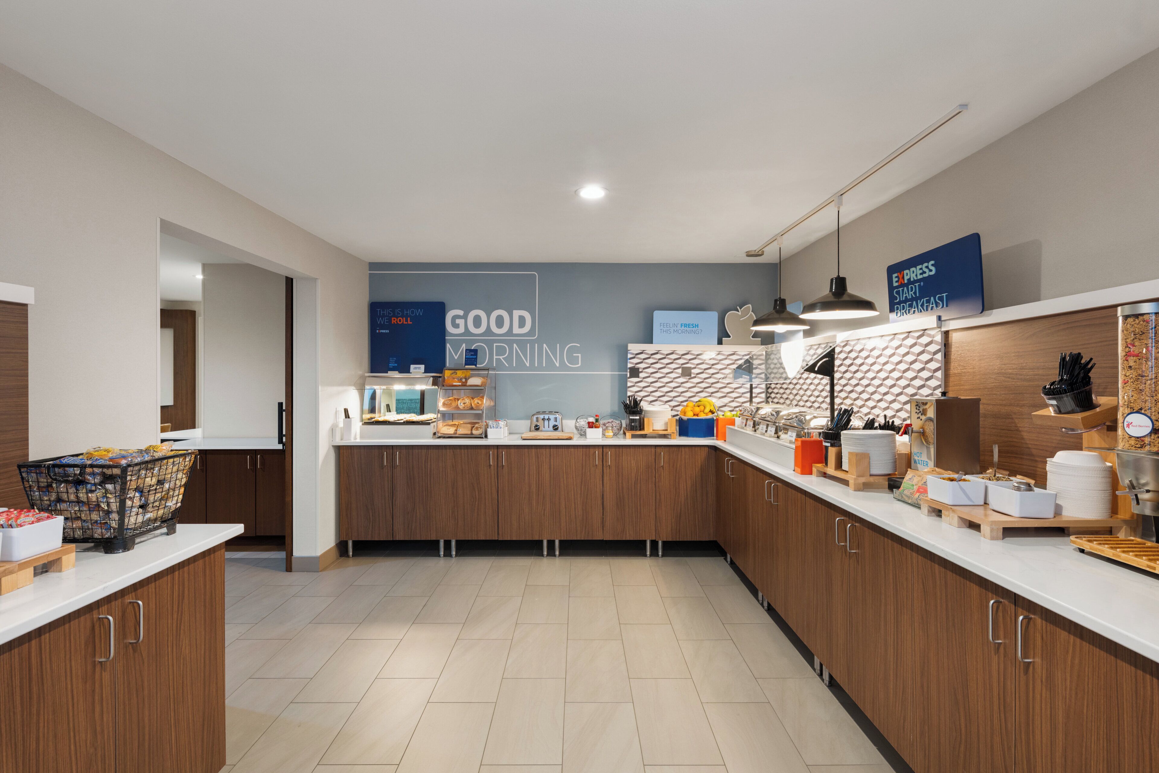A modern kitchen with wooden cabinets, a breakfast bar, and a sign that reads 'GOOD MORNING'.
