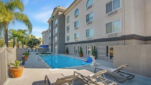 A hotel pool area with lounge chairs, a pool, and potted plants. - Holiday Inn Express Hotel & Suites San Diego-Sorrento Valley by IHG (San Diego)