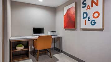 Un espacio de oficina moderno con un escritorio, una silla, una impresora y una estantería.