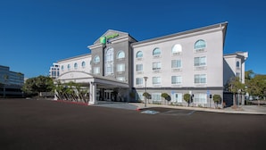 A Holiday Inn hotel with a modern design, featuring a covered entrance and multiple windows. - Holiday Inn Express Hotel & Suites San Diego-Sorrento Valley by IHG (San Diego)