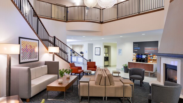 A spacious lobby with a staircase, seating areas, and a coffee station. - Holiday Inn Express Arcata / Eureka - Airport Area by IHG (McKinleyville)
