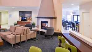 A modern lounge area with a fireplace, seating, and a coffee station. - Holiday Inn Express Arcata / Eureka - Airport Area by IHG (McKinleyville)