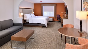 A hotel room with a bed, a sofa, a small table, a round table, and a chair. - Holiday Inn Express Arcata / Eureka - Airport Area by IHG (McKinleyville)