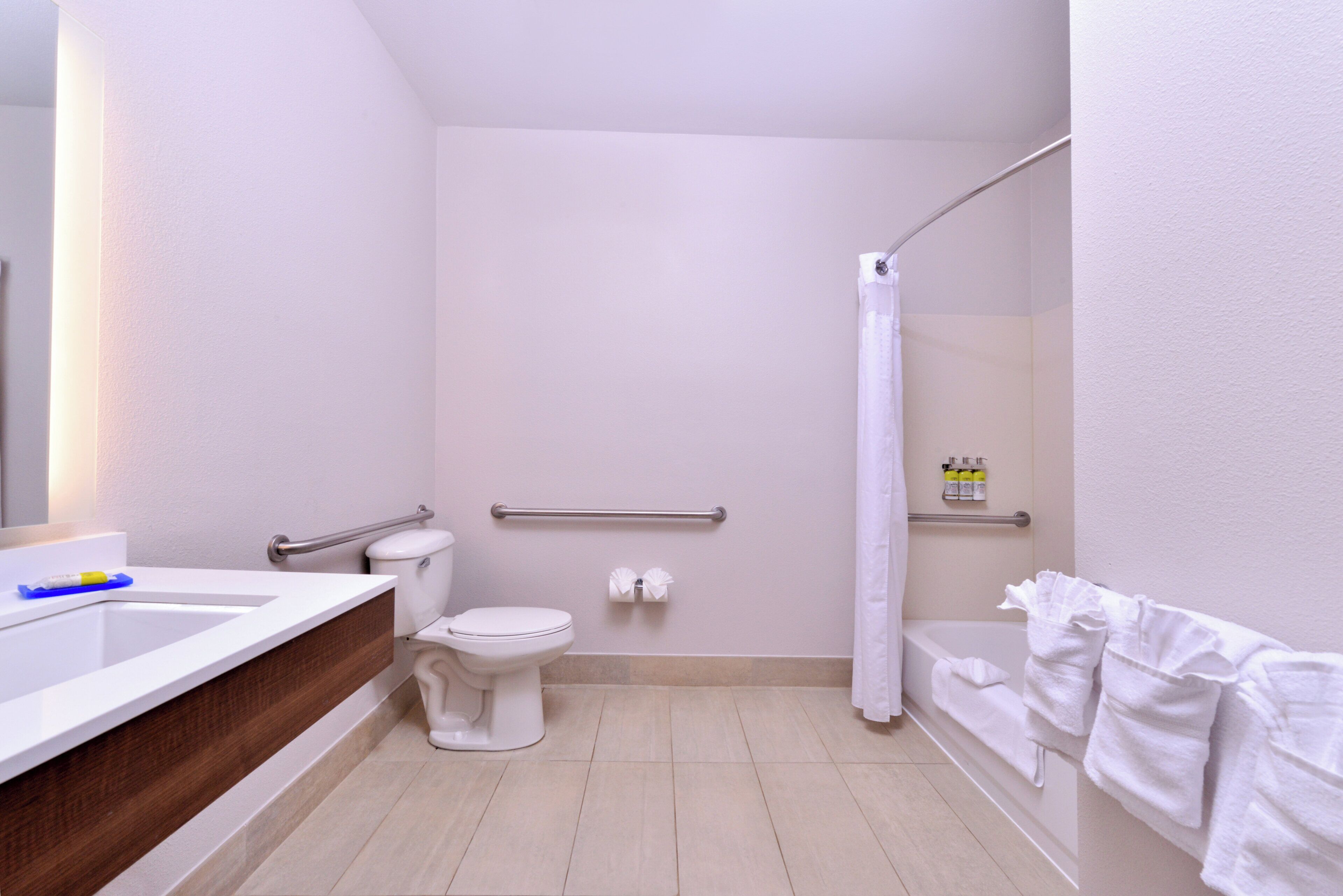 A bathroom with a toilet, a sink, a shower, and a towel rack.