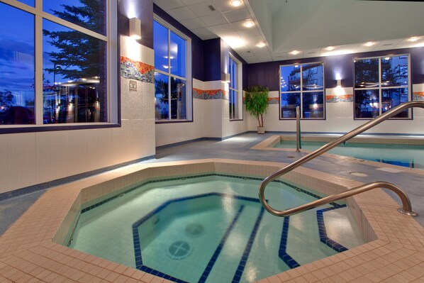 An indoor swimming pool with clear water, a metal handrail, and large windows. - Holiday Inn Express Hotel & Suites Calgary S-Macleod Trail S by IHG (Calgary)