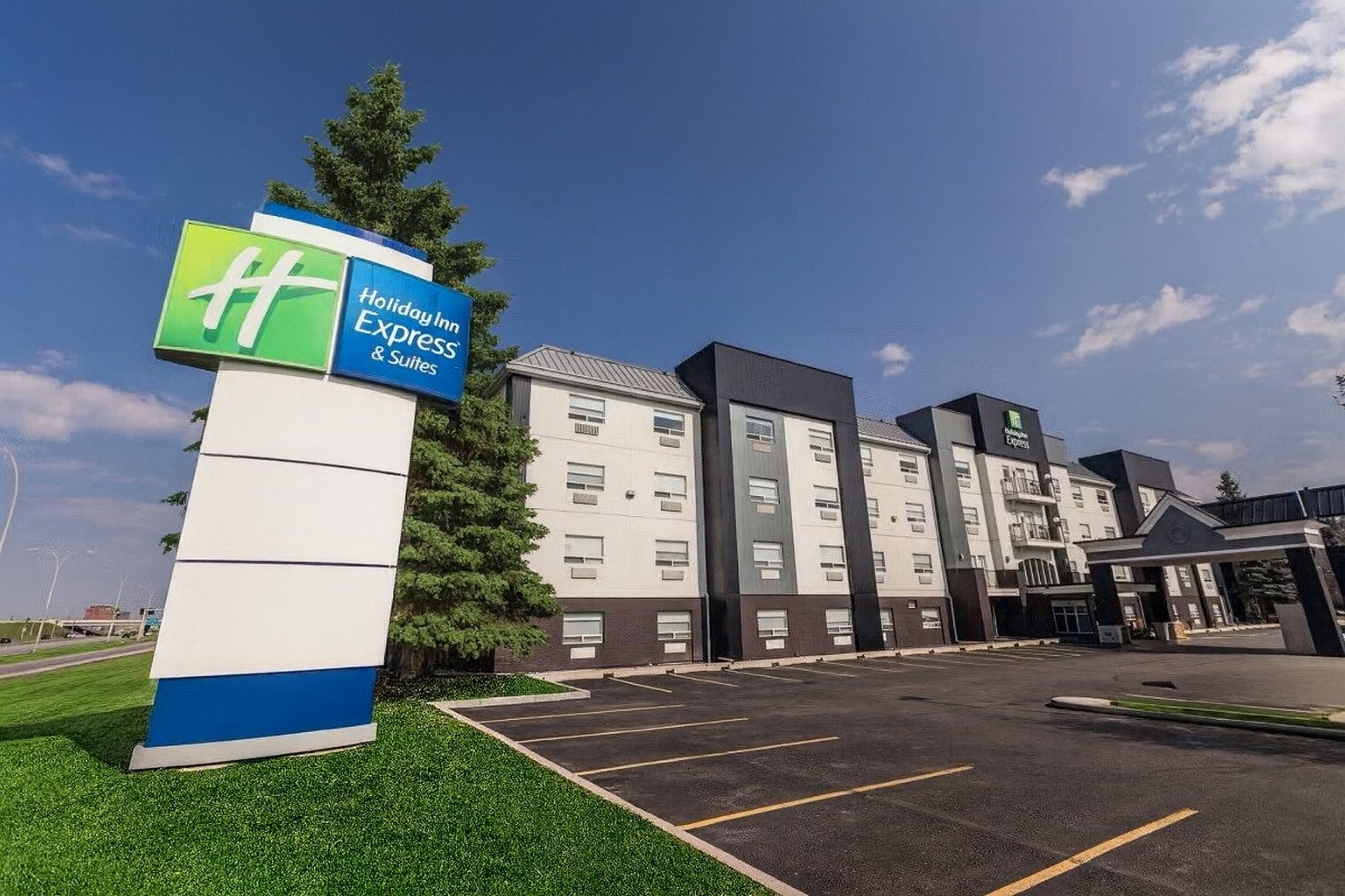 A Holiday Inn Express & Suites hotel with a parking lot and a large sign.