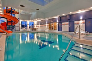 Una piscina techada, sillones reclinables de piscina