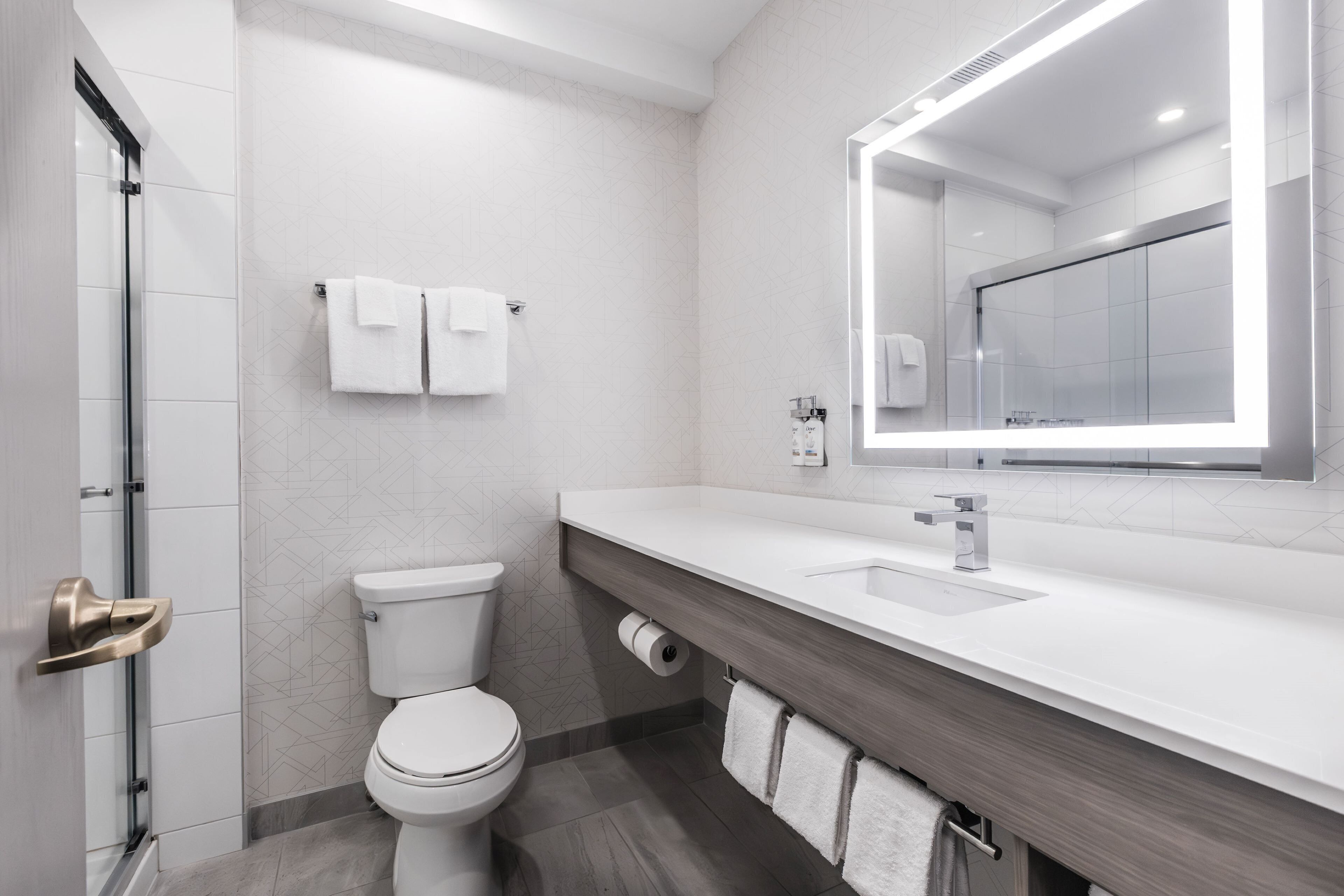 A modern bathroom with a toilet, sink, and shower.