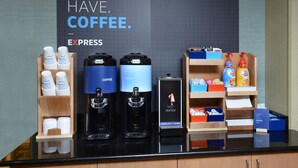 A coffee station with two coffee dispensers, a hot water station, and a coffee grinder. - Holiday Inn Express Durham by IHG (Durham)