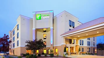 Un hotel Holiday Inn Express con un diseño moderno, que cuenta con un letrero llamativo, varias ventanas y una entrada bien iluminada.