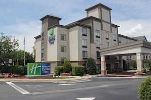 A Holiday Inn Express & Suites hotel with a modern design, featuring a large sign, a covered entrance, and landscaped surroundings. - Holiday Inn Express & Suites Charlotte-Concord-I-85 by IHG (Concord)