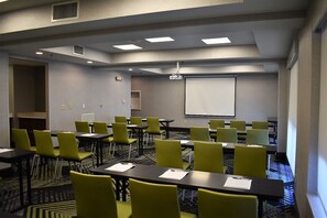 A conference room with multiple tables and chairs, a projector screen, and a carpeted floor. - Holiday Inn Express & Suites Charlotte-Concord-I-85 by IHG (Concord)