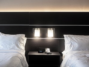 A hotel room with two beds, a nightstand with a phone and a digital clock, and wall-mounted lighting. - Holiday Inn Express & Suites Charlotte-Concord-I-85 by IHG (Concord)