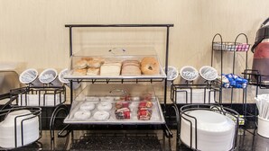 A breakfast buffet with various pastries and bread.