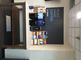 Una estación de café con un letrero que dice “NECESIDAD ABSOLUTA: CAFÉ” y una máquina de café.