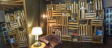 A cozy room with a leather sofa, a lamp, and a wall of wooden crates used as shelves.