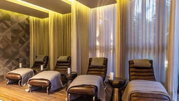Un cuarto de spa con sillones de masaje, suelo de madera y pared con diseño.