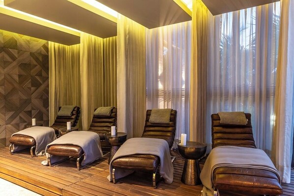 A spa room with massage chairs, wooden flooring, and a patterned wall. - Movich Hotel Las Lomas (Rionegro)