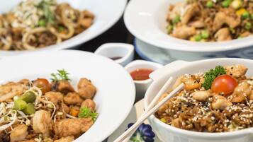 Three plates of stir-fried dishes with various vegetables and shrimp, served on white plates with chopsticks.