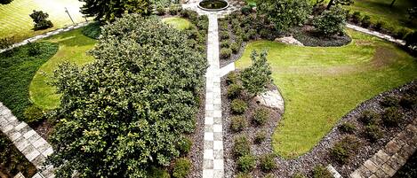 A landscaped garden with a central circular area, pathways, and a gazebo.