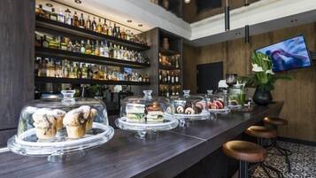 A bar area with shelves of liquor bottles, a TV screen, and a counter with food displays.