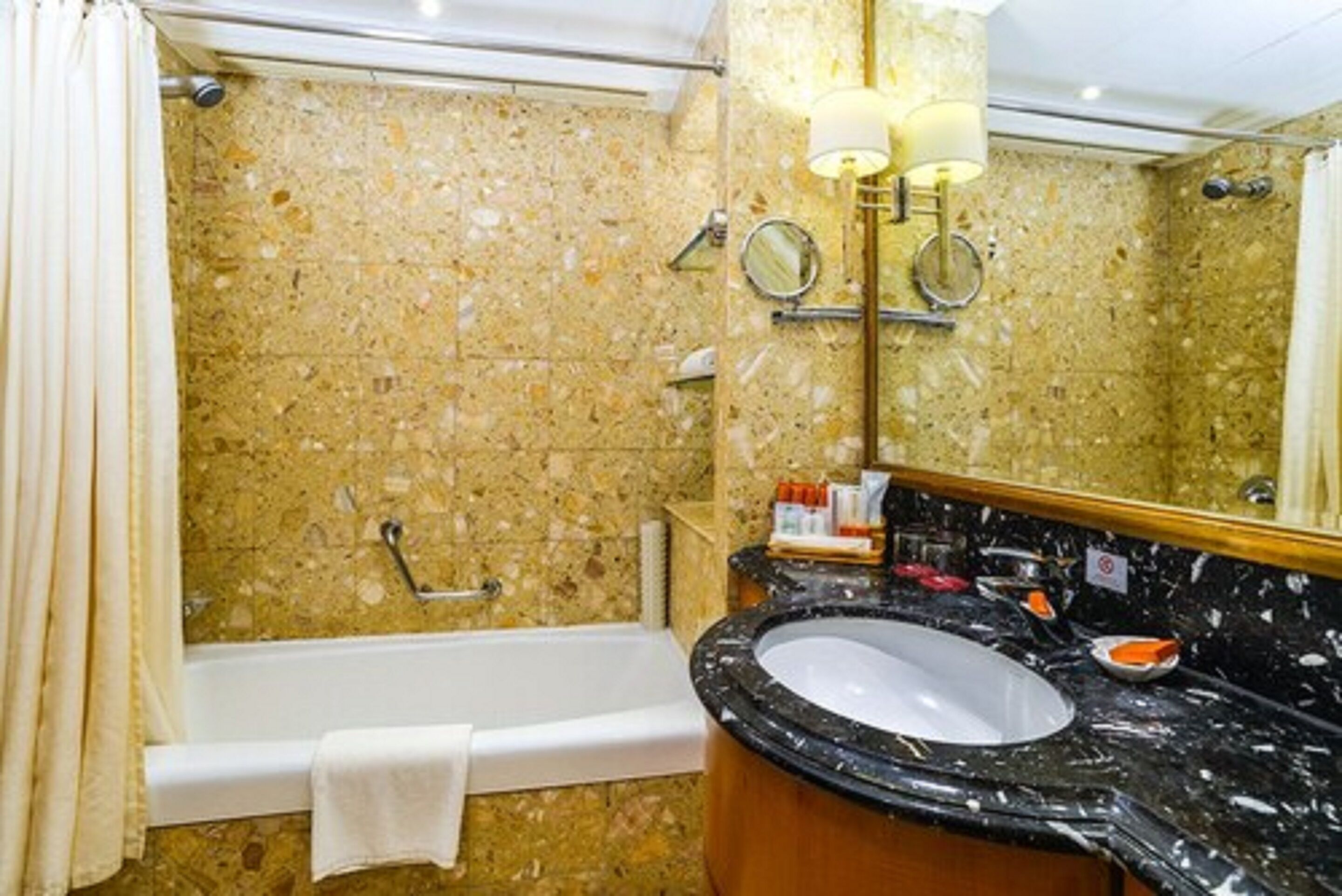 A bathroom with a bathtub, a sink, and a mirror.
