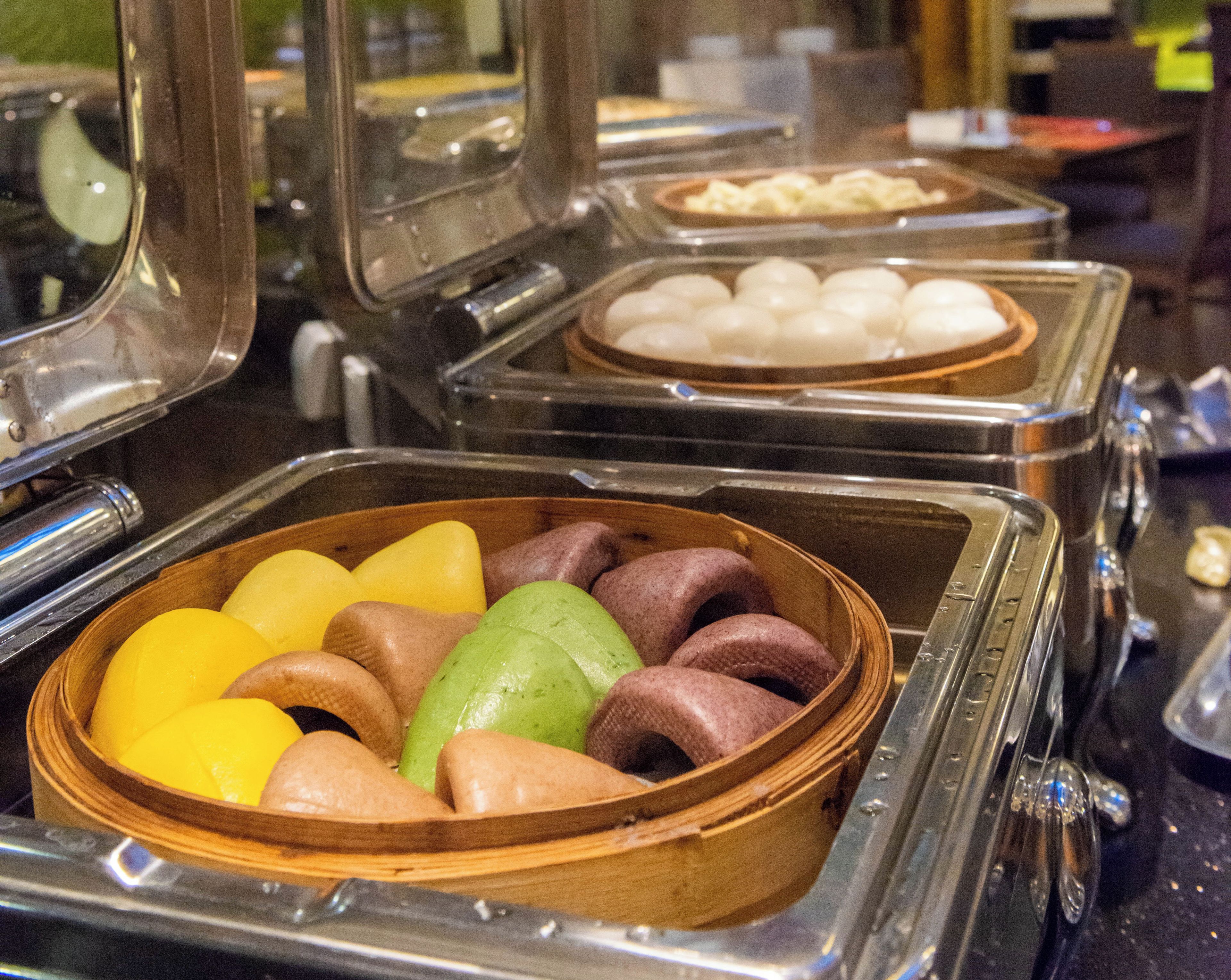 Buffet com diversos alimentos em recipientes variados.