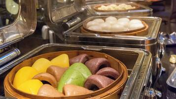 Buffet com diversos alimentos em recipientes variados.