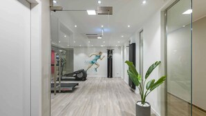 A modern hallway with a treadmill, a wall-mounted air purifier, and a potted plant. - Mercure Hotel Köln Belfortstraße (Cologne)
