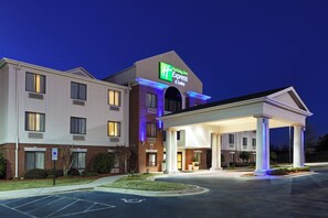 A Holiday Inn Express & Suites hotel with a covered entrance and a parking lot.