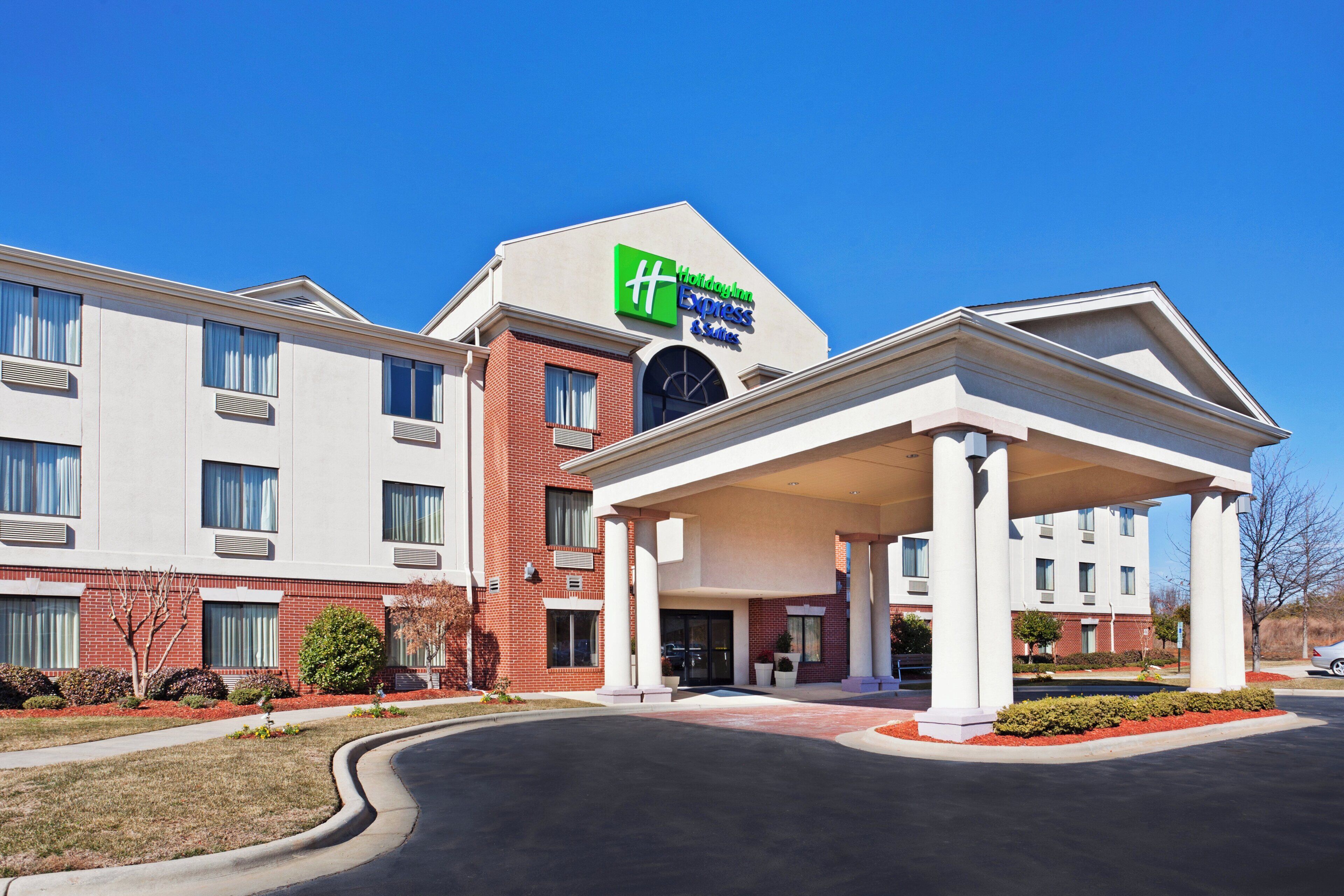 A Holiday Inn Express & Suites hotel with a covered entrance and a brick facade.