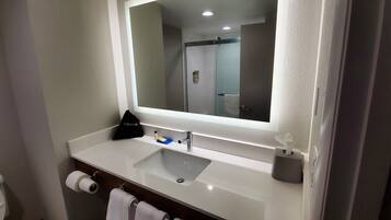 A bathroom with a white sink, a mirror, a towel, and a hairdryer.