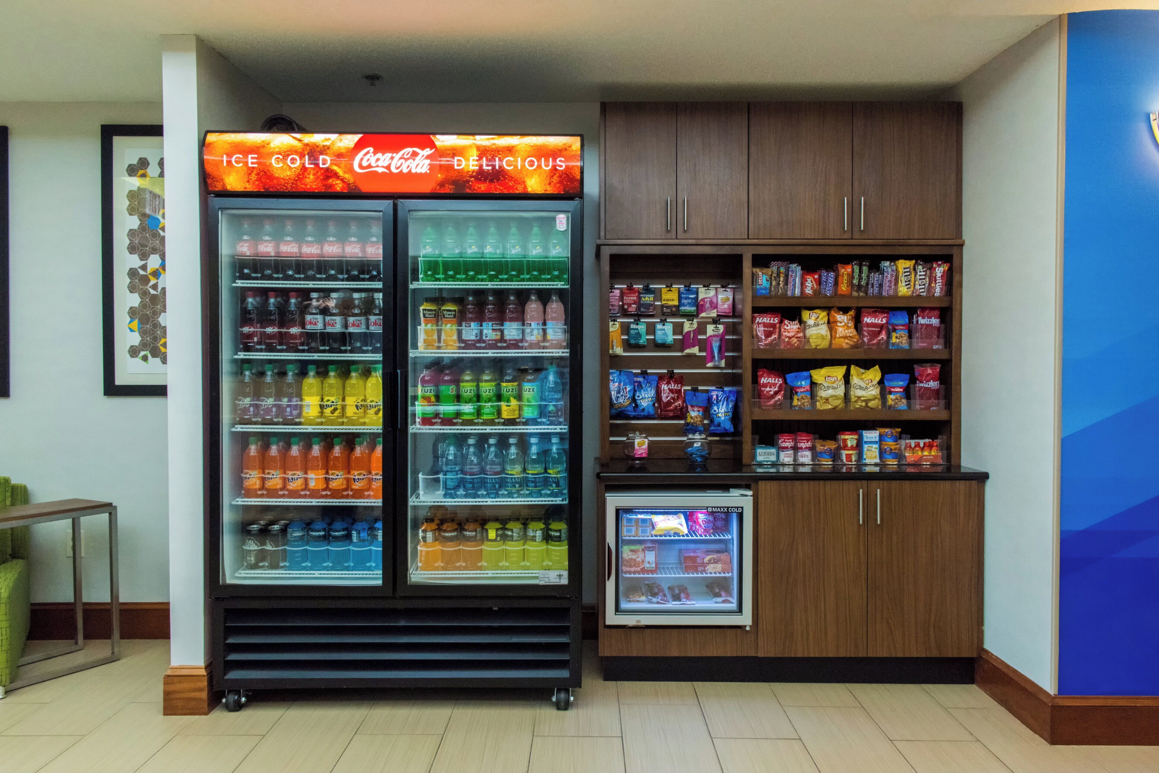 Máquina expendedora con un rótulo de Coca-Cola, llena de bebidas y aperitivos.