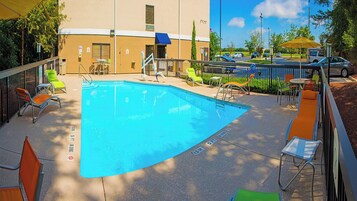 Una piscina al aire libre de temporada, sombrillas