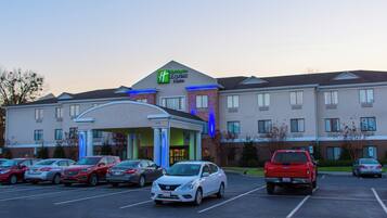 Un hotel Holiday Inn Express con un estacionamiento lleno de coches.
