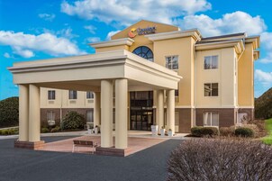 Un hotel con entrada cubierta, un letrero llamativo y fachada de ladrillo.