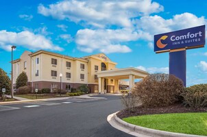 Edificio de Comfort Inn & Suites, con cielo despejado y un césped bien cuidado al frente.