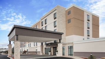A multi-story hotel with a covered entrance and a parking lot.