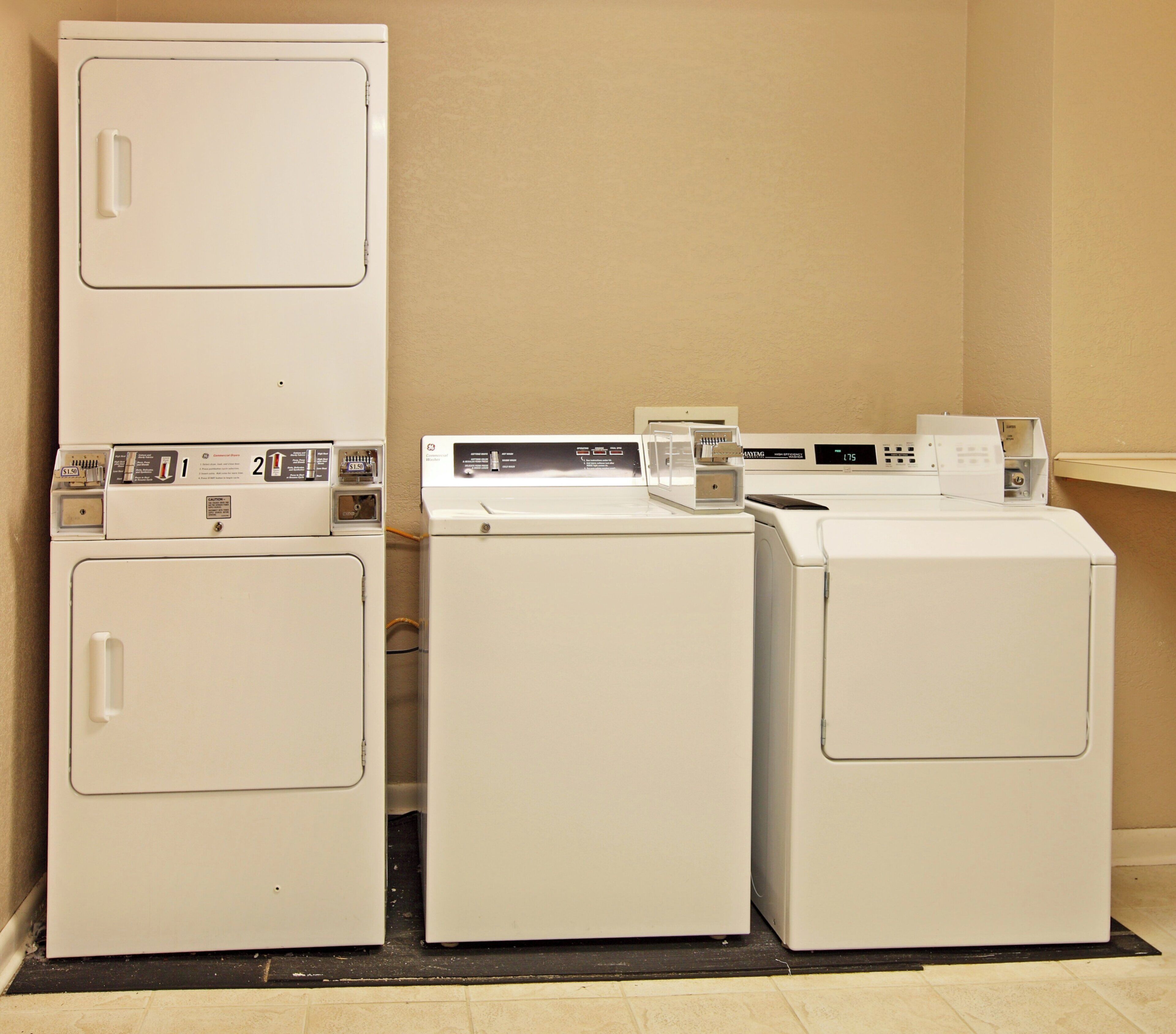 A laundry area with two dryers and a washing machine.