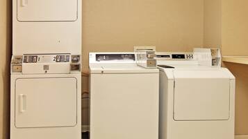 A laundry area with two dryers and a washing machine.